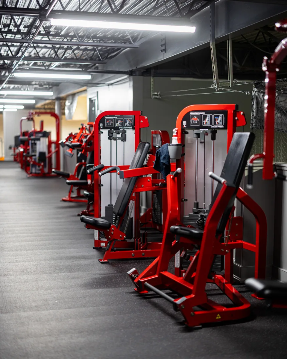 Row of red strength machines on the Impact Zone NJ training floor in Norwood, New Jersey